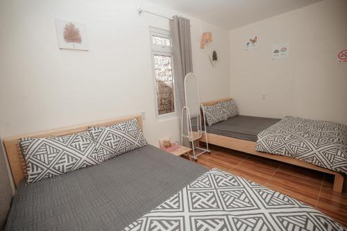 a bedroom with two beds and a window at Homestay BỒ CÔNG ANH in Da Lat
