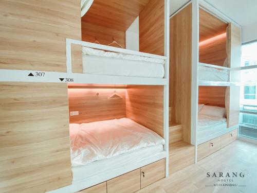 a room with three bunk beds in it at Sarang Hostel at City Centre in Kota Kinabalu