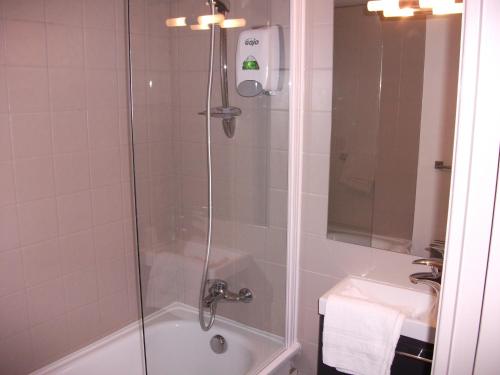 ein Badezimmer mit einer Dusche, einer Badewanne und einem Waschbecken in der Unterkunft Le Minotel in Vitré