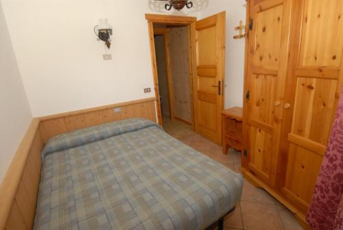 a small bedroom with a bed and an open door at Baita Guana in Livigno