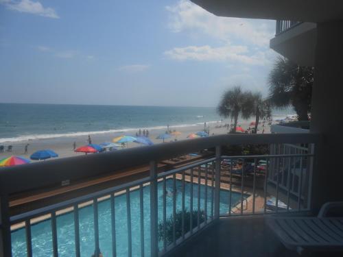 a balcony with a view of the beach and a swimming pool at 0105 Waters Edge Resort condo in Myrtle Beach