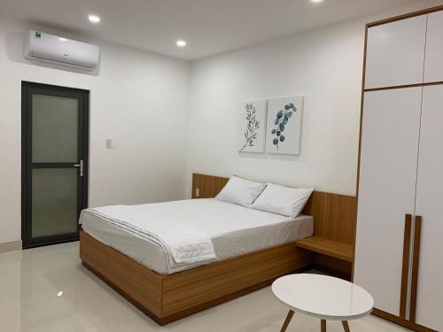 a bedroom with a bed and a table in it at New Studio 202 District 9 in Xóm Dầu Bình Thới