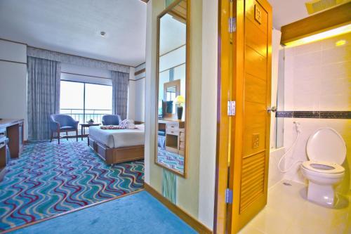 Asia Cha-am Hotel في تشا أم: غرفة في الفندق مع مرحاض وغرفة نوم