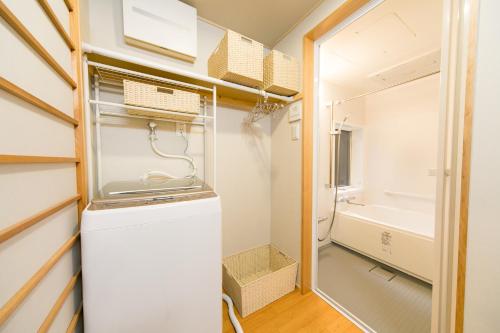 a small kitchen with a refrigerator and a bathroom at Nishodo Machiya HIKARU GOJO in Kyoto