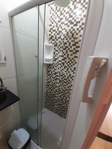 y baño con ducha de cristal y aseo. en residencia bem viver, en Arraial do Cabo