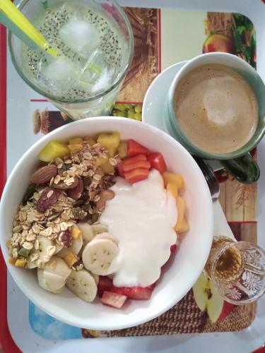 a bowl of food with vegetables and a cup of coffee at Naga Hostel & Café in Thakhek