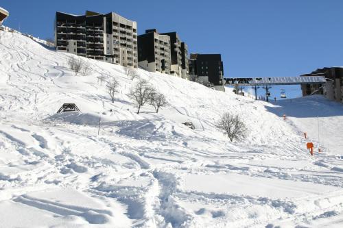 a snow covered hill with buildings in the background at Résidence Azureva Les Menuires in Les Menuires