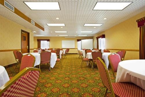 a conference room with tables and chairs and a whiteboard at Candlewood Suites Grand Rapids Airport by IHG in Grand Rapids