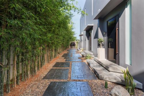 a stone path with trees on the side of a building at Villa Kyoto in Layan Beach