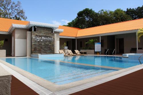 una gran piscina frente a un edificio en Court Meridian Hotel & Suites, en Olóngapo