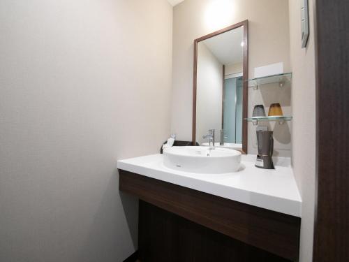 a bathroom with a sink and a mirror at Iwakuni Kokusai Kanko Hotel in Iwakuni