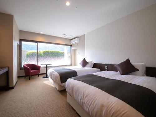 a hotel room with two beds and a window at Iwakuni Kokusai Kanko Hotel in Iwakuni