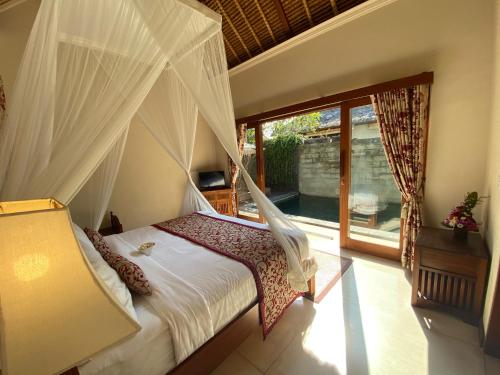 a bedroom with a bed with a mosquito net at Rumah Dadong in Ubud