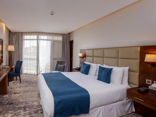 Postel nebo postele na pokoji v ubytování Golden Tulip Canaan Kampala