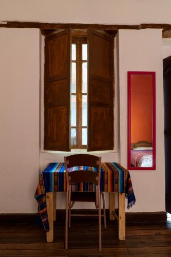 a table and a chair in a room with a window at Blue Door Housing Historic Quito in Quito