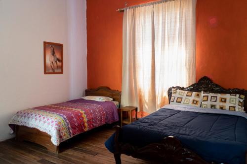 a bedroom with two beds and a window at Blue Door Housing Historic Quito in Quito