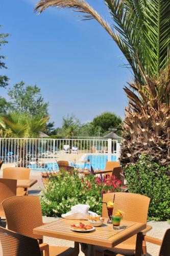 une table avec de la nourriture et des boissons sur une terrasse dans l'établissement Azureva Le Grau du Roi, au Grau-du-Roi