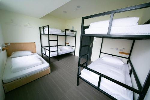 a room with three bunk beds in it at 客旅家青年旅館 Travelers Plus in Chiayi City