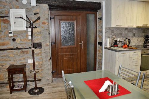 cocina con mesa y puerta de madera en Traditional Stone Villa "To Petrino", en Florina