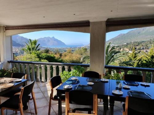 a dining room with tables and chairs and a large window at Victorskloof Lodge in Hout Bay