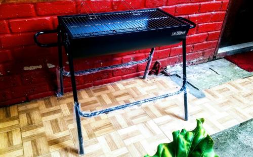 a black grill sitting next to a red brick wall at Oemah Kajoe Lembang in Lembang