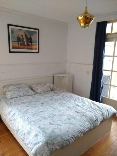 a bedroom with a bed with a blue comforter at Folmerhuis in Oostkapelle