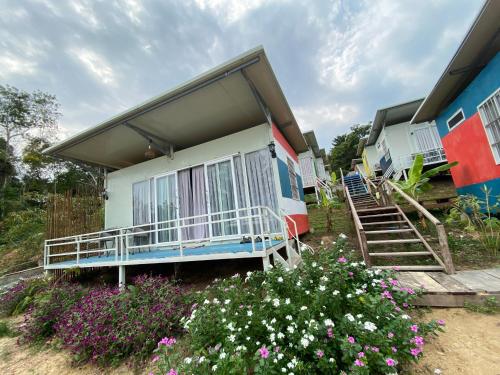 ein Haus mit einer Veranda und Blumen davor in der Unterkunft Naroth Beach Bungalow in Koh Rong