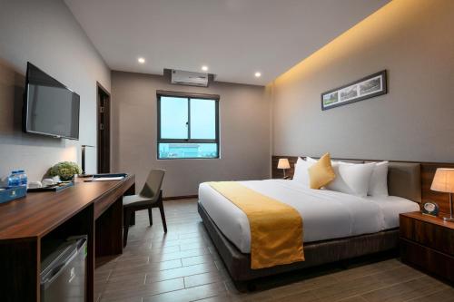 a hotel room with a bed and a desk at Golden Season Hotel in Ninh Binh