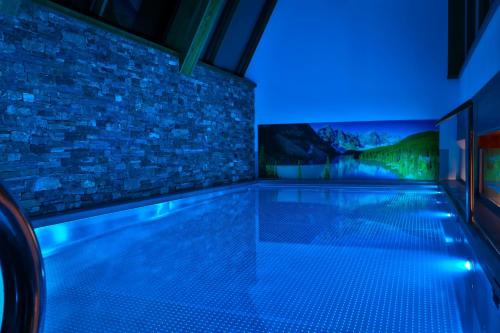 a swimming pool with a blue lighting in a building at Hotel Bystra in Białka Tatrzanska