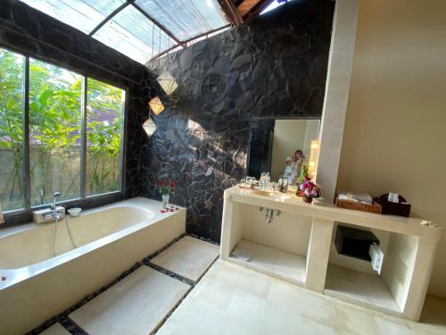 a bathroom with a tub and a sink and a mirror at Rumah Dadong in Ubud