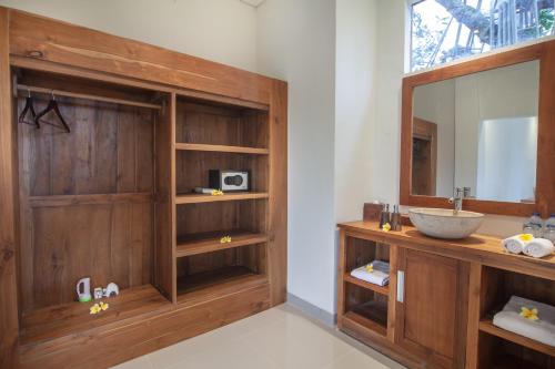 W łazience znajduje się umywalka i lustro. w obiekcie Mahadana Ubud w mieście Ubud