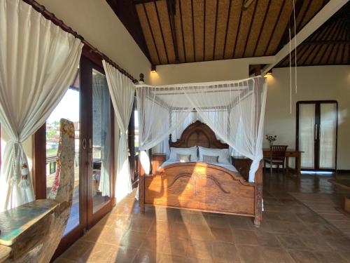 a bedroom with a bed with a mosquito net at Rumah Dadong in Ubud