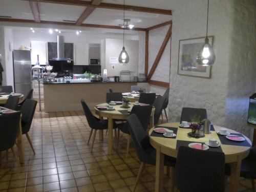 a dining room with tables and chairs and a kitchen at Hotel Central in Erlangen