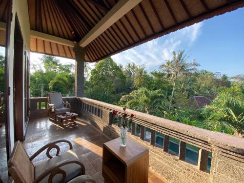 a balcony of a house with a view of the forest at Rumah Dadong in Ubud