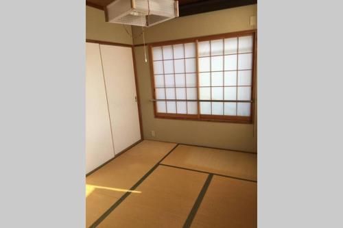 an empty room with two windows and a floor at 駅近-最大収容9人JR小岩駅まで徒歩圏Leo小岩301 in Tokyo