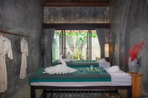 um quarto com uma cama com dois cisnes em Mai Holiday by Mai Khaolak - Adult Zone em Khao Lak