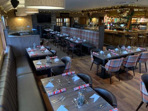 a restaurant with tables, chairs, and tables in it at Standing Stones Hotel in Stromness