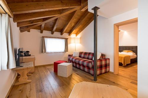 a living room with a bed and a couch at Hotel Saluver in Celerina