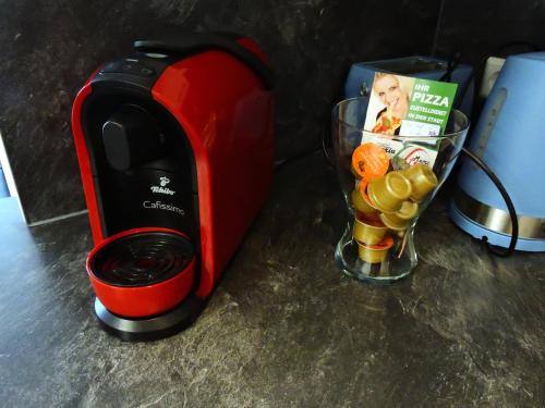 a red toaster sitting next to a cup of fruit at 305 Berlin, Studio Apartment, 38m2 2-4 Pers in Klagenfurt
