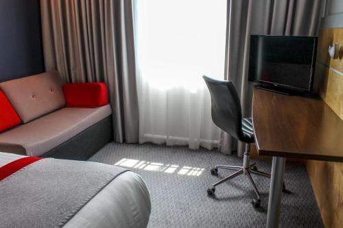 a hotel room with a bed and a desk and a television at Holiday Inn Express Doncaster by IHG in Doncaster