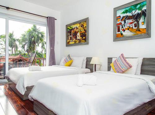 1 dormitorio con 2 camas y ventana en Ylang Garden Villa, en Hoi An