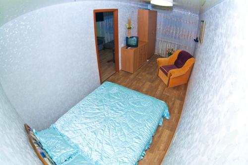 einen Blick über ein Schlafzimmer mit einem Bett und einem Stuhl in der Unterkunft 2х комн. центр. на Соборной in Krementschuk