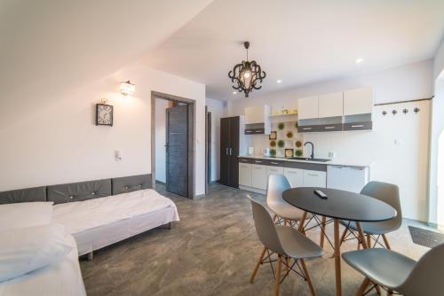 a living room with a bed and a table and chairs at Apartamenty pod Gromadzyniem in Ustrzyki Dolne