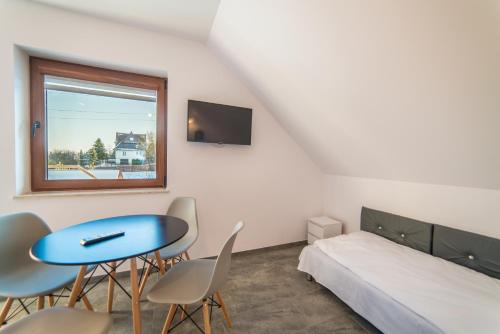 a bedroom with a bed and a table and chairs at Apartamenty pod Gromadzyniem in Ustrzyki Dolne