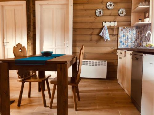 a kitchen with a wooden table and chairs in a kitchen at Club Thermal Village Cegled in Cegléd