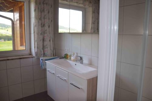 łazienka z umywalką i oknem w obiekcie Ferienhaus Mitterbauer w mieście Oberhofen am Irrsee