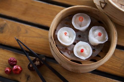 a wooden bowl of food with chopsticks on a table at Taj Palace, New Delhi in New Delhi