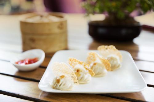 a white plate with dumplings on a table at Taj Palace, New Delhi in New Delhi