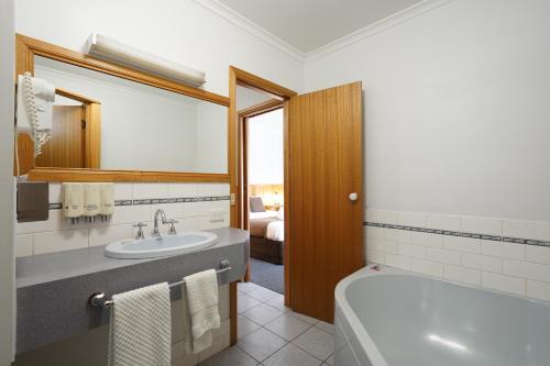a bathroom with a tub and a sink and a bath tub at Best Westlander Motor Inn in Horsham