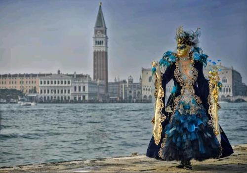 a woman in a blue dress standing next to the water at Villa Stefania in Noventa Padovana